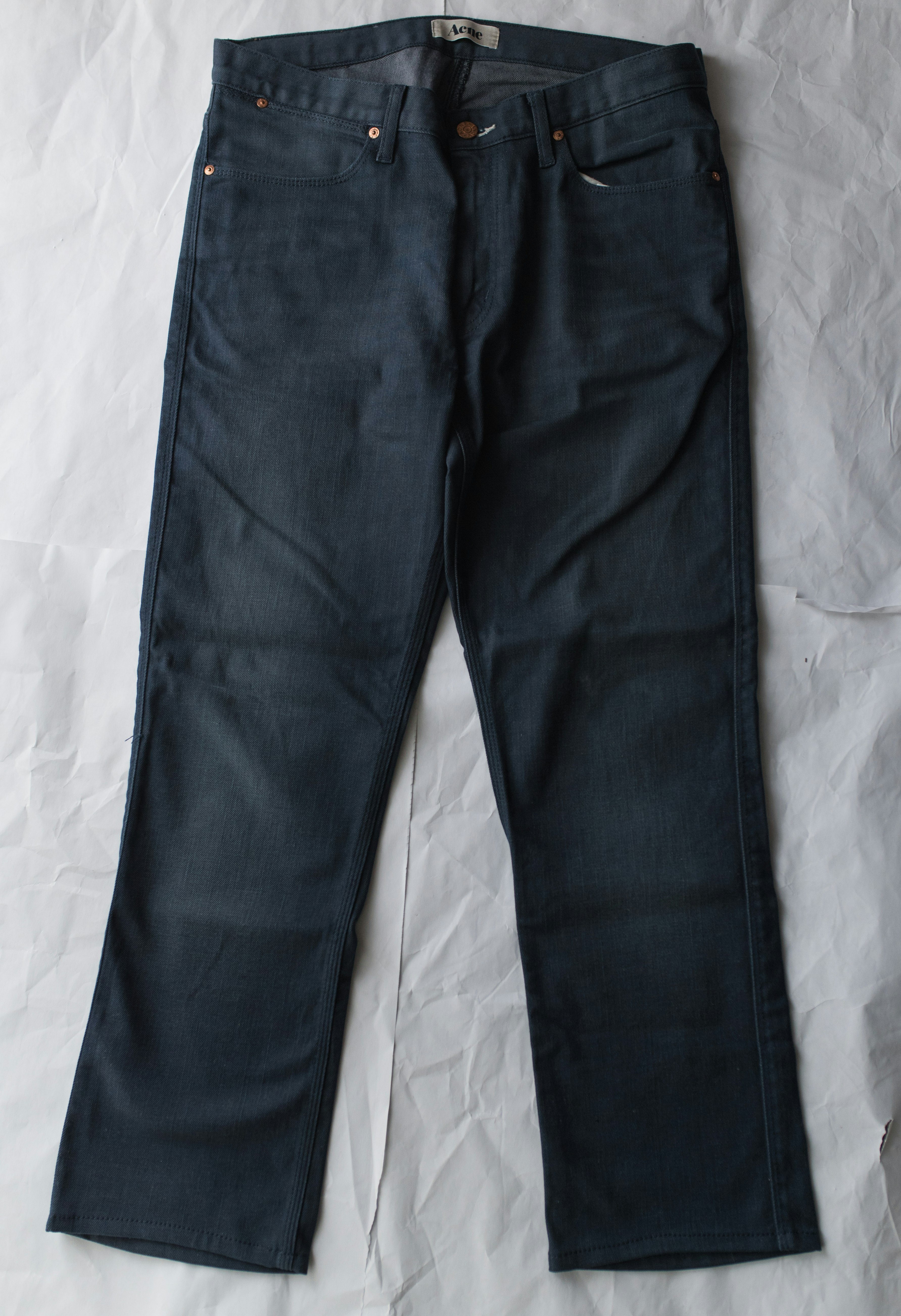 blue denim jeans on white textile